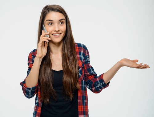 Cheerful young girl talking on her phone